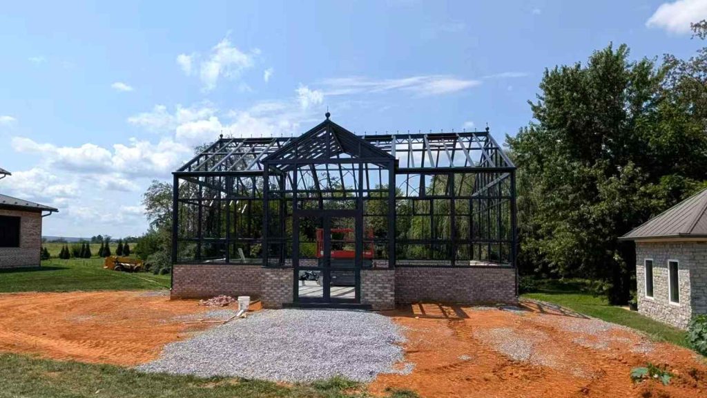Wide landscape view large custom Victorian greenhouse construction site Virginia countryside garden conservatory
